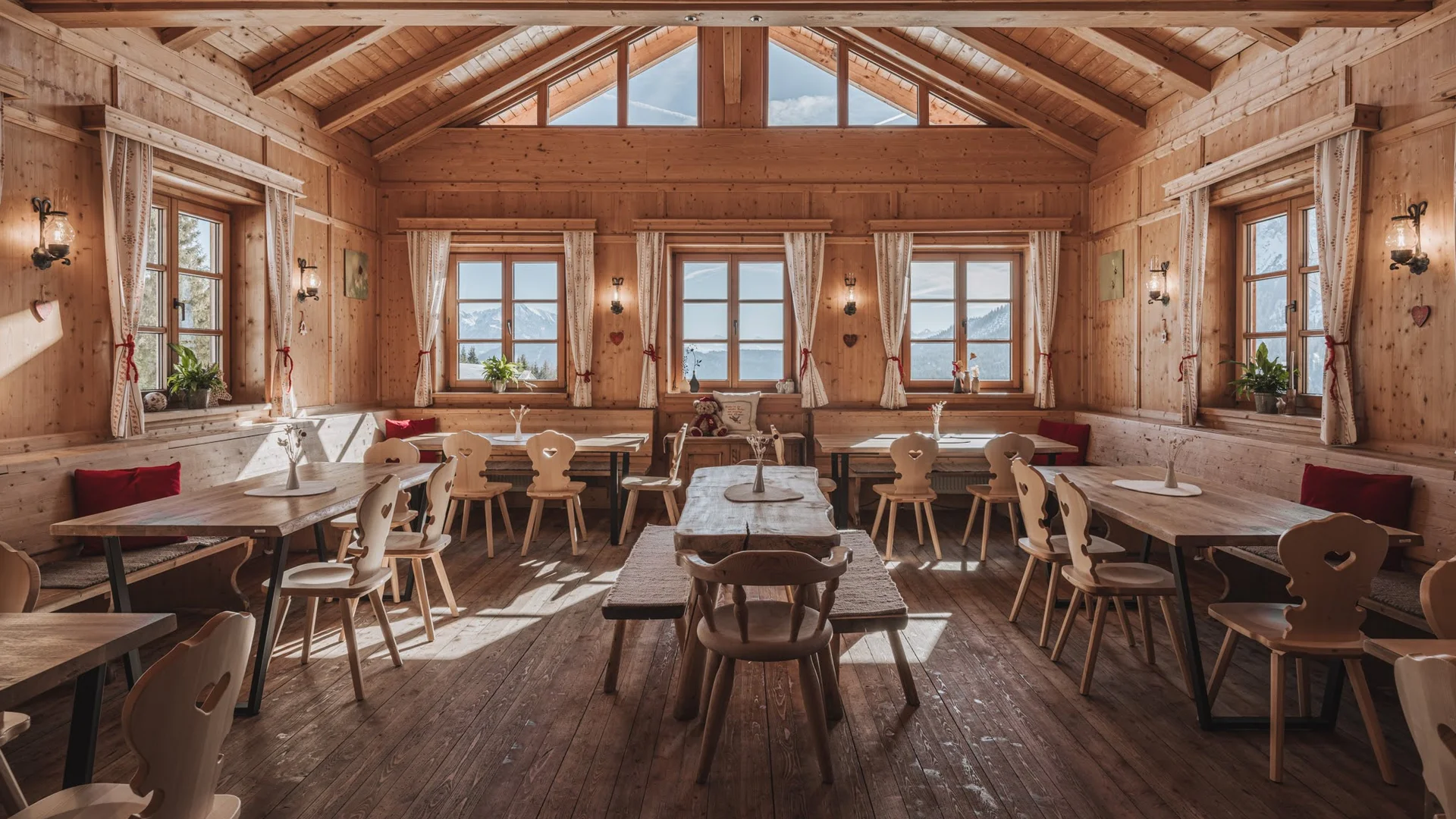 Ihre Almhütte in Tirol Rustikaler Gastraum in Holzhütte mit Fenstern und Bergblick