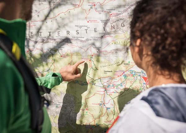 Sehenswürdigkeiten in Leutasch Person zeigt auf Wanderkarte der Alpenregion Wetterstein