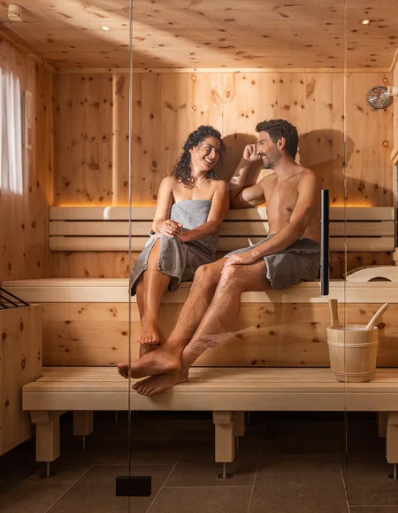 Entspannen im Hotel mit Sauna in Österreich Paar entspannt sich zusammen in einer Sauna aus Holz