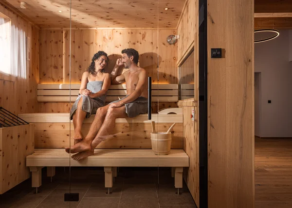 Vom Familienbetrieb zum echten Biohotel Paar entspannt sich zusammen in einer Sauna aus Holz