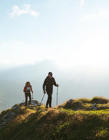 Der Bio-Blog des Leutascherhof Zwei Wanderer auf einem grasbewachsenen Berg bei Sonnenlicht