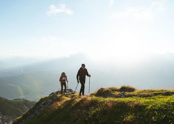 Vom Familienbetrieb zum echten Biohotel Zwei Wanderer auf einem grasbewachsenen Berg bei Sonnenlicht