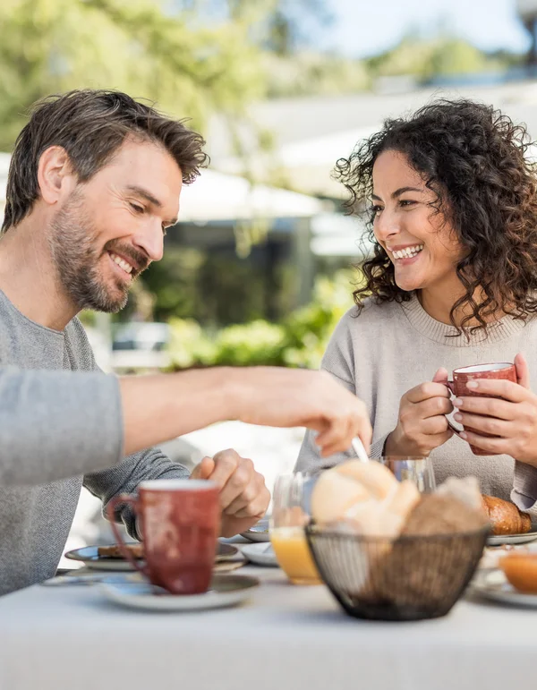 Unterkunft in Leutasch Paar genießt Frühstück im Freien mit Kaffee und Brötchen am Tisch