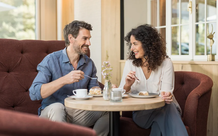 Bio-Getränke in Tirol Paar isst Kuchen und trinkt Kaffee in einem gemütlichen Café