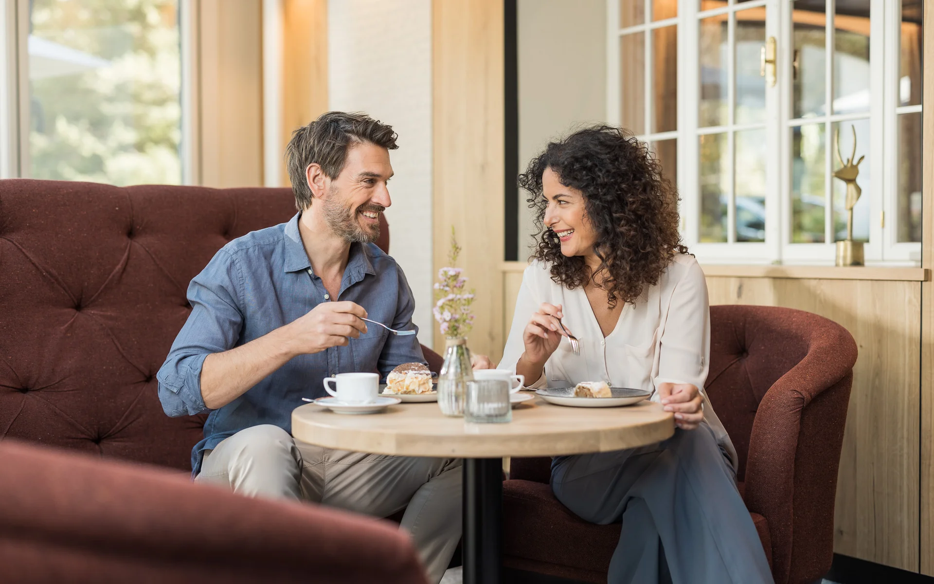 Werfen Sie einen Blick in die Bildergalerie Paar isst Kuchen und trinkt Kaffee in einem gemütlichen Café