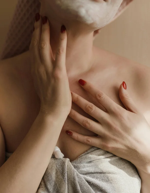 Ihr Wellnesshotel in Leutasch Frau trägt Gesichtsmaske und hält Hand an Hals und Brust