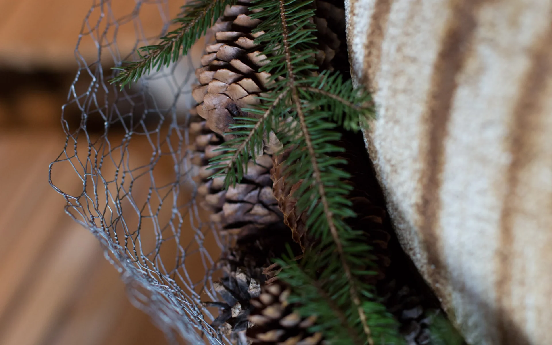 Werfen Sie einen Blick in die Bildergalerie Weihnachtliche Dekoration mit Tannenzapfen und Tannenzweigen in Maschendrahtkorb