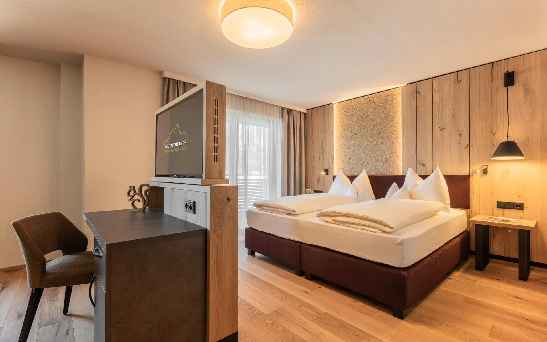 Werfen Sie einen Blick in die Bildergalerie Modernes Hotelzimmer mit Doppelbett, Holzwänden und Schreibtisch mit TV