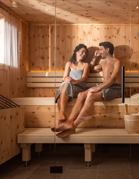 Biohotel Leutascherhof – Ihr Kraftort in den Tiroler Alpen Paar entspannt sich zusammen in einer Sauna aus Holz