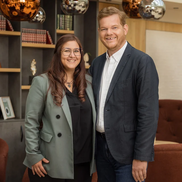 Biohotel Leutascherhof – Ihr Kraftort in den Tiroler Alpen Zwei lächelnde Personen in Business-Outfits in moderner Lounge