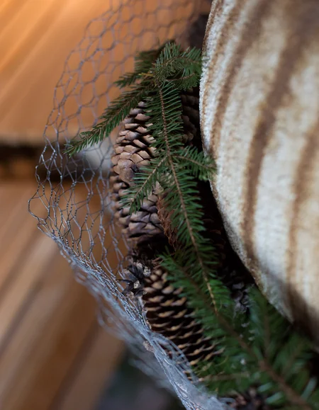 Biohotel Leutascherhof – Ihr Kraftort in den Tiroler Alpen Weihnachtliche Dekoration mit Tannenzapfen und Tannenzweigen in Maschendrahtkorb