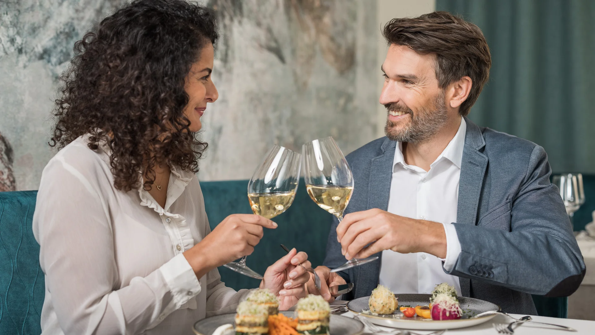 Biohotel Leutascherhof – Ihr Kraftort in den Tiroler Alpen Paar stößt mit Wein im Restaurant an